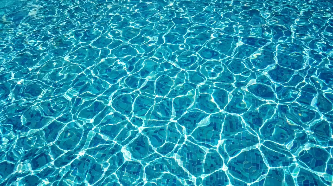 Agua de piscina cristalina tras la mantención, con el fondo azul parejo