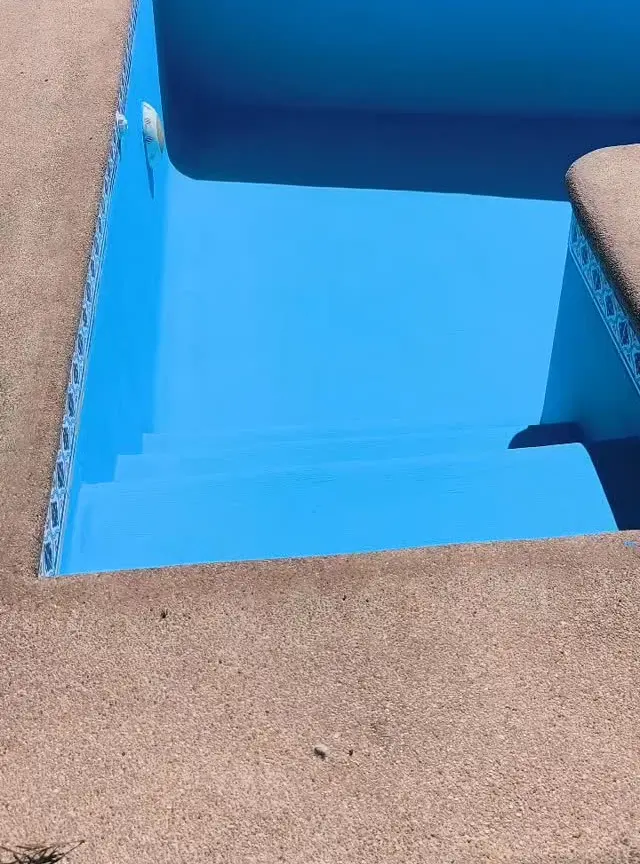 Piscina recién pintada de azul, con la segunda mano terminada